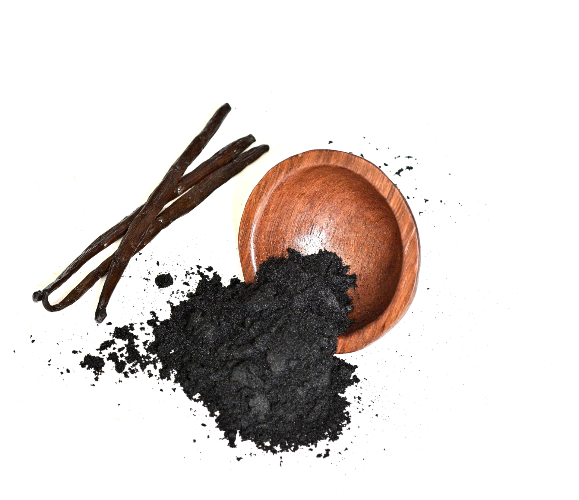 Wooden bowl of black vanilla caviar seeds beside vanilla pods