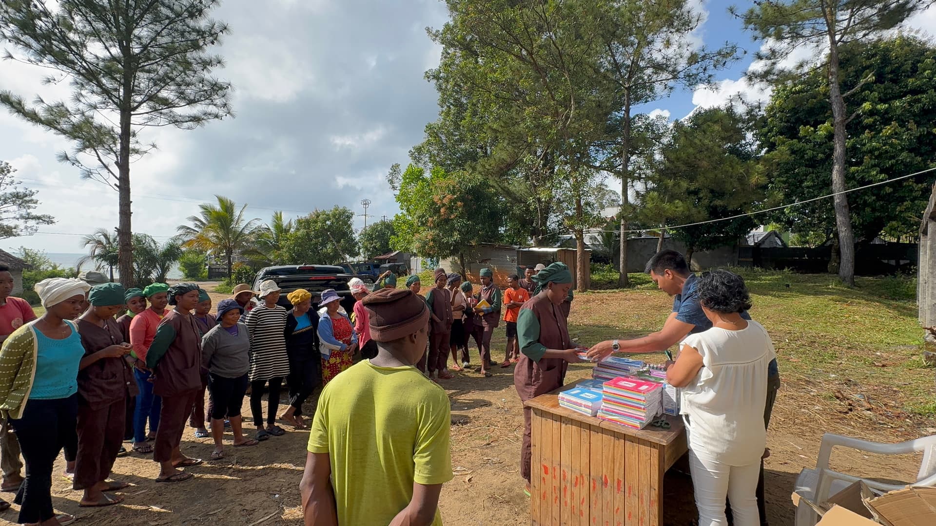 M-Vanilla team distributing school supplies to a Malagasy community